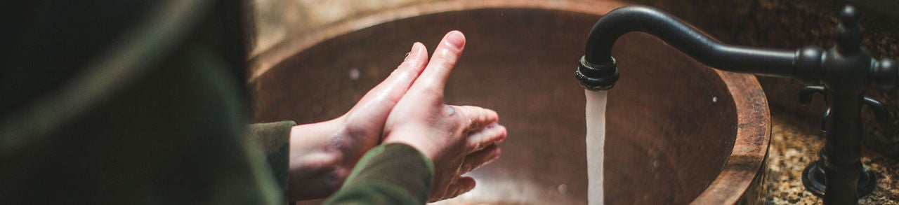 Se laver les mains dans l’évier de la salle de bain